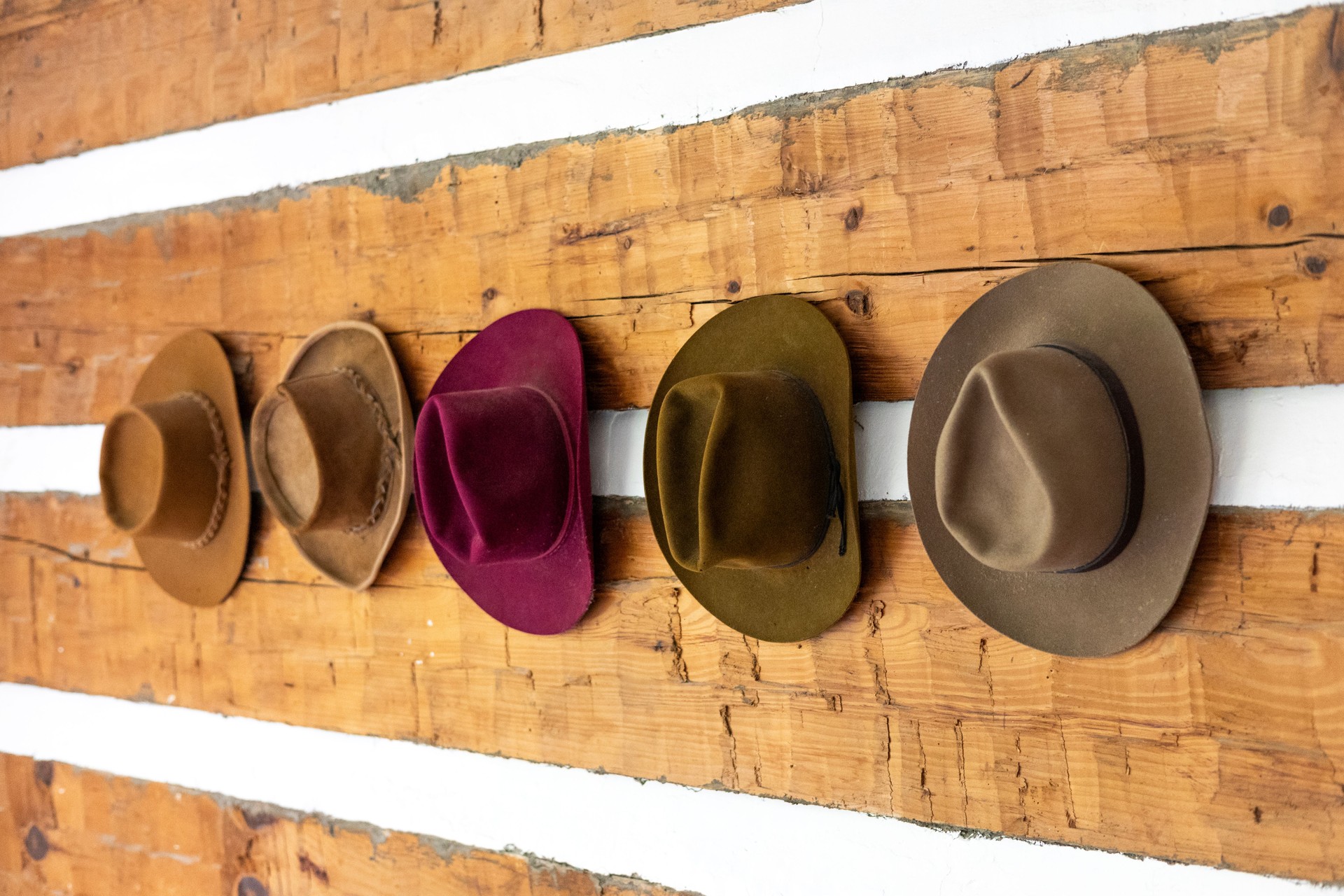 Felt Cowboy Hats on a Rustic Wooden Wall